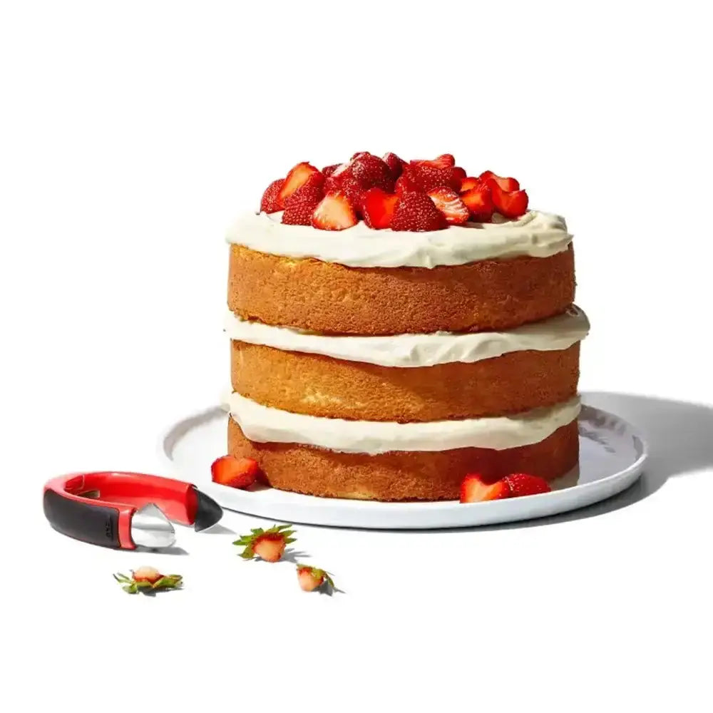 Oxo good grips strawberry huller with three layer golden sponge cake filled with white cream and fresh red strawberry slices