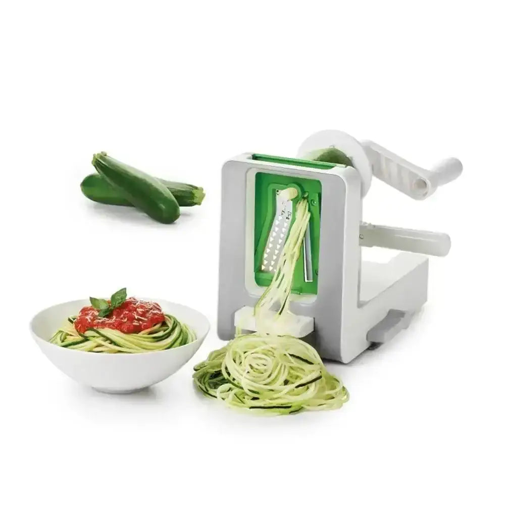 Zucchini noodles being made with a spiralizer on a white background
