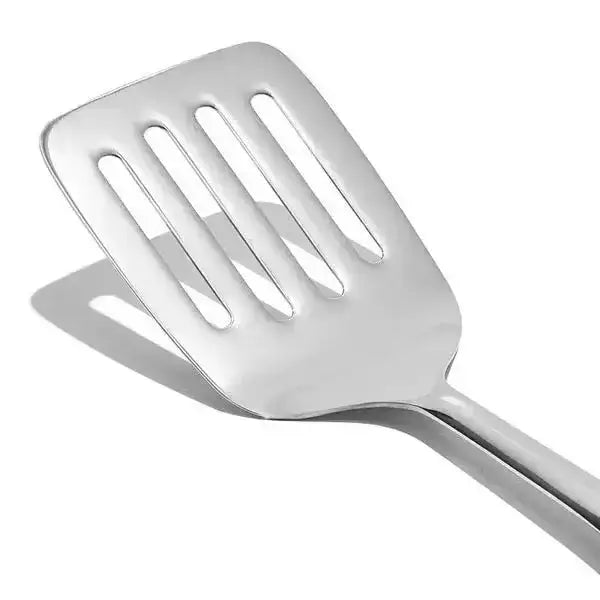 Oxo stainless steel cooking turner with a shiny flat slotted head and smooth handle for easy flipping