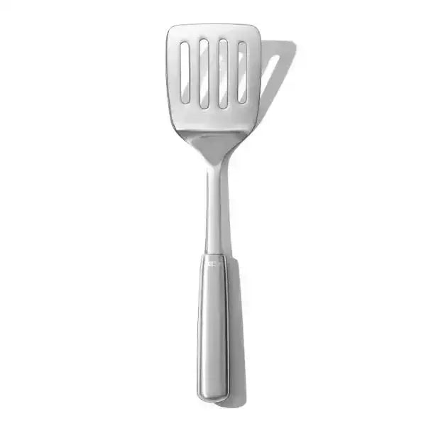 Oxo stainless steel cooking turner with a sleek silver spatula head featuring four vertical slots