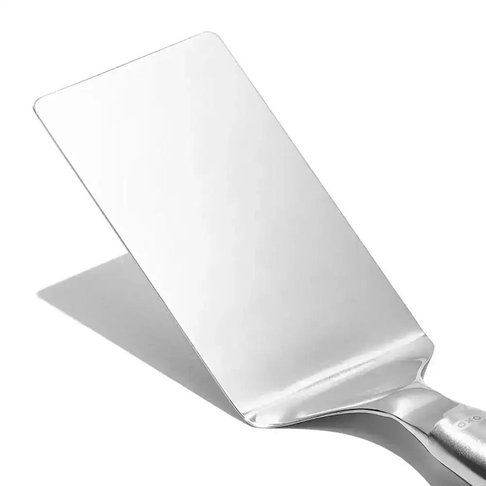 Oxo stainless steel lasagna turner with shiny rectangular blade and smooth handle for easy serving