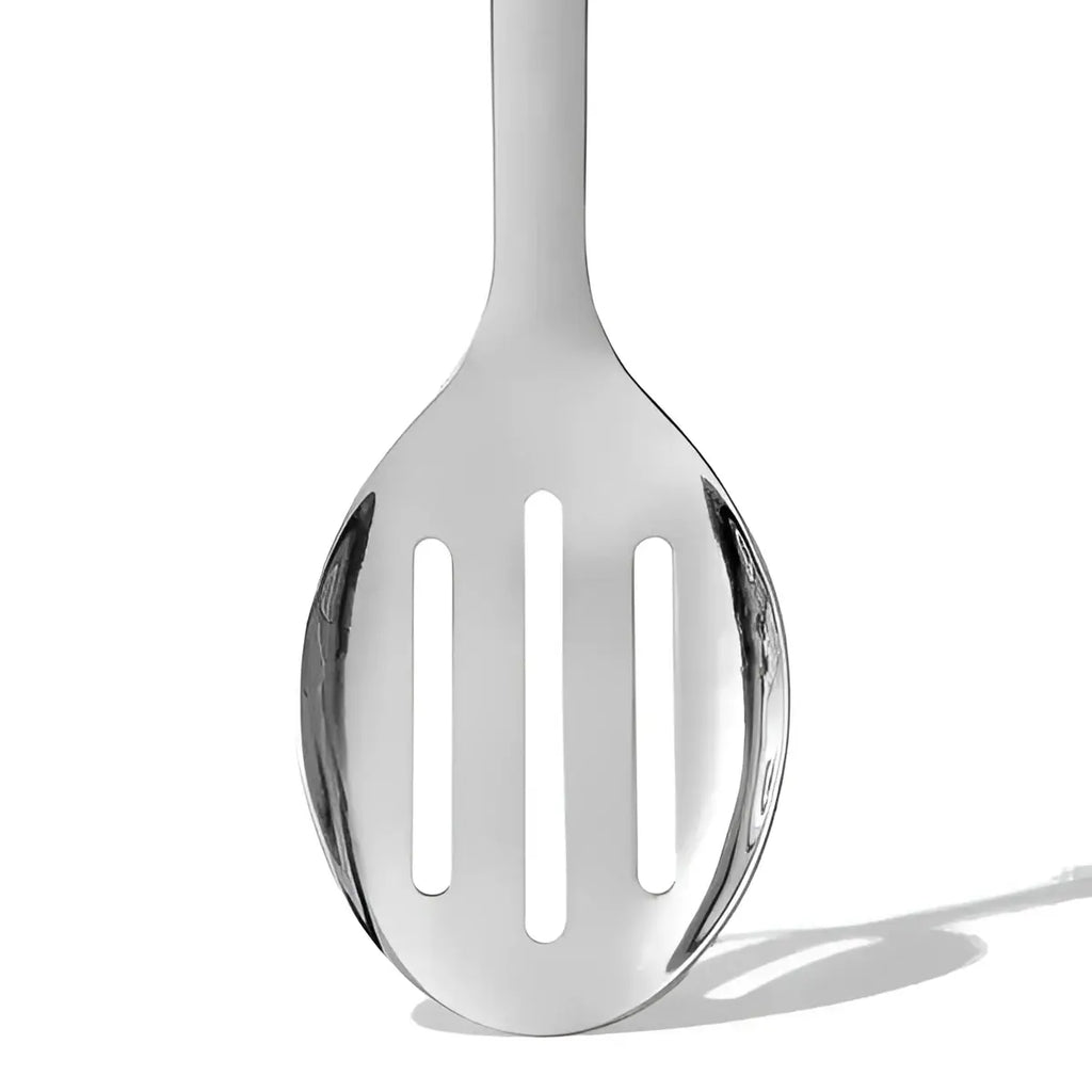 Oxo stainless steel slotted serving spoon in silver with three vertical slots and a smooth rounded handle