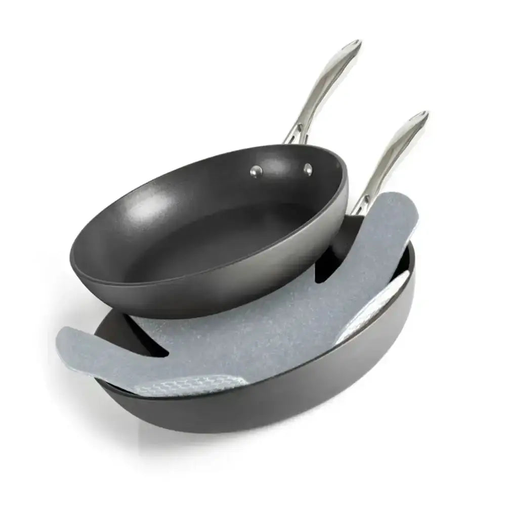 Set of two frying pans with a stand on a white background