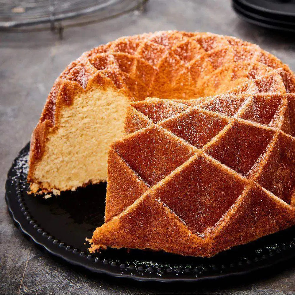 Bundt cake with a slice removed on a black plate