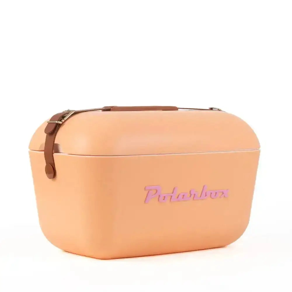 Peach-colored polarbox classic retro cooler box 20l with brown leather strap and pink cursive branding