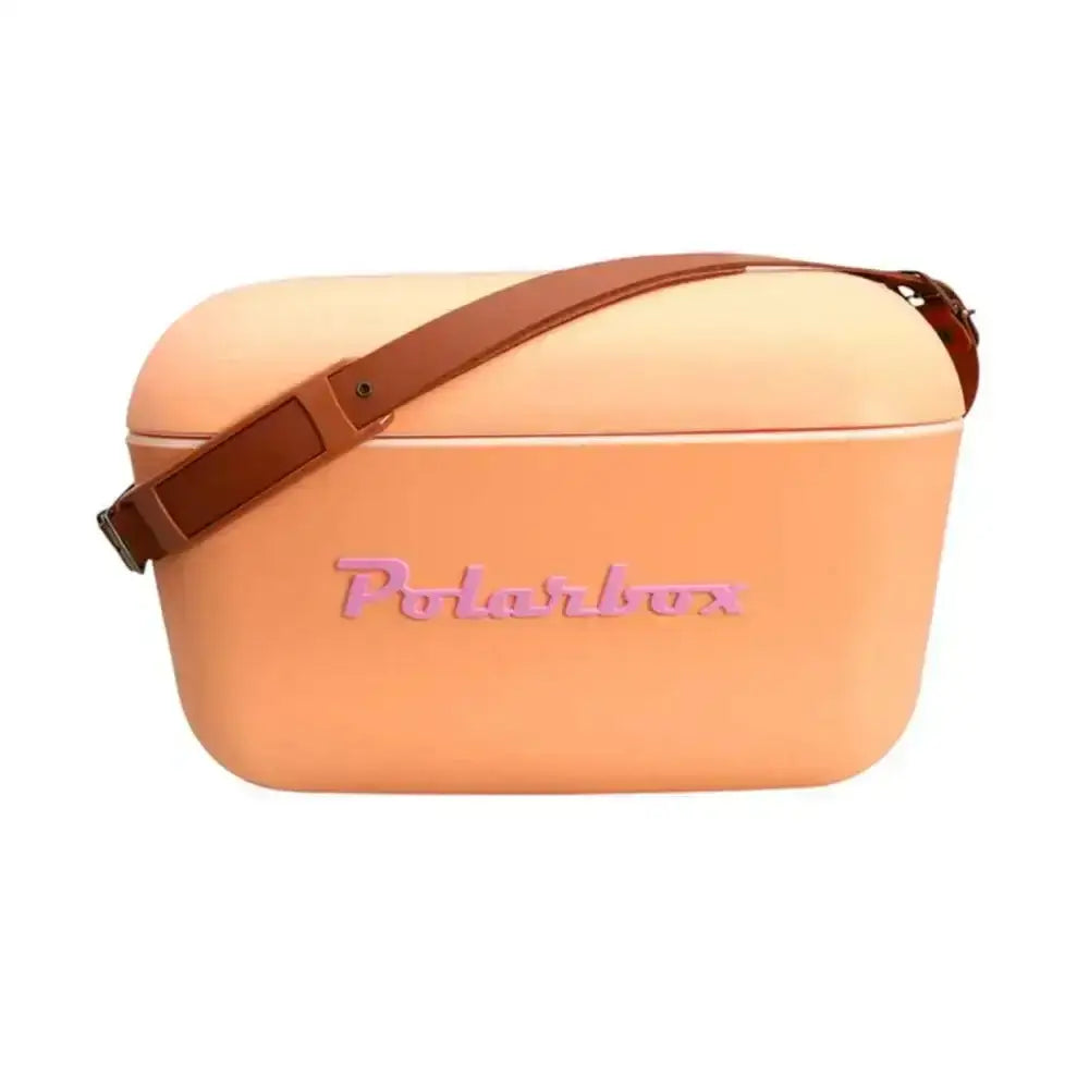 A peach-colored polarbox classic retro cooler box 20l with a brown leather strap and pink embossed branding