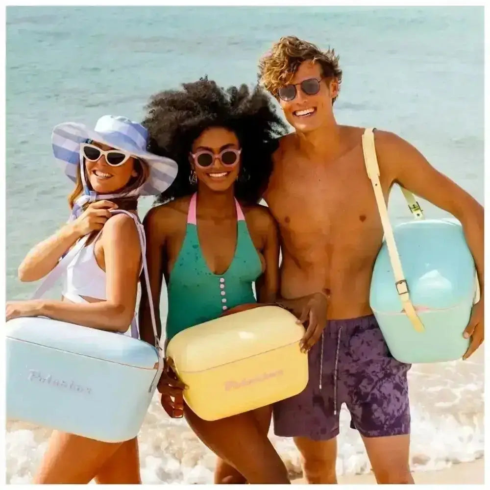 Three people on a beach holding colorful bags with 'Polo Ralph Lauren' branding.