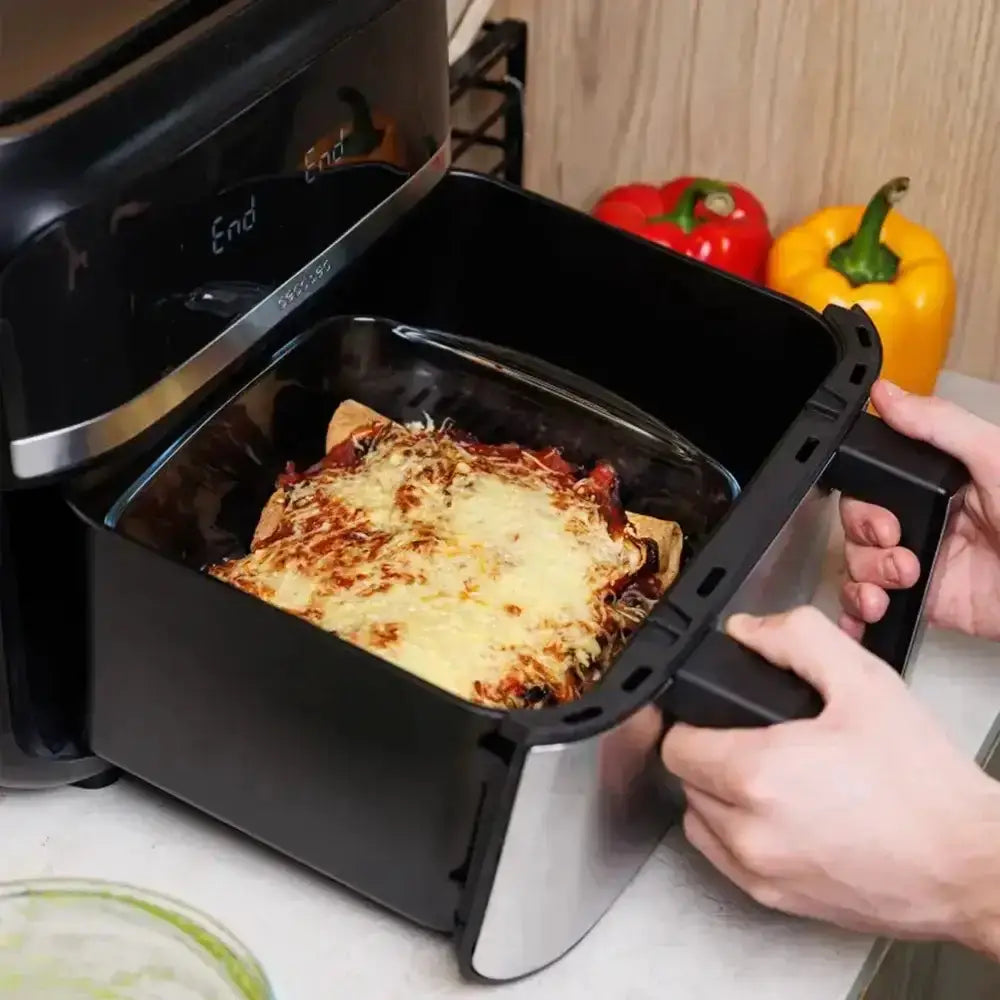 Person removing a cooked dish from an open air fryer.