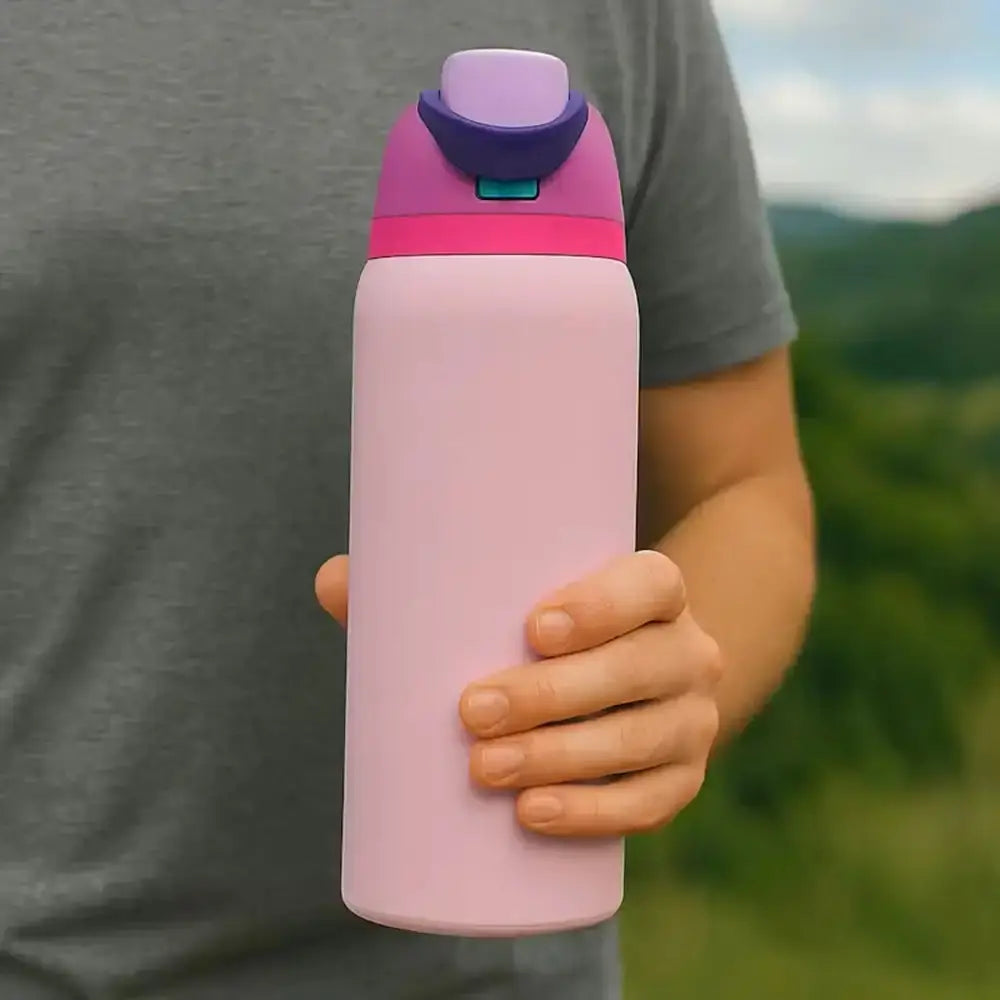 Person holding a pink water bottle with a purple cap outdoors