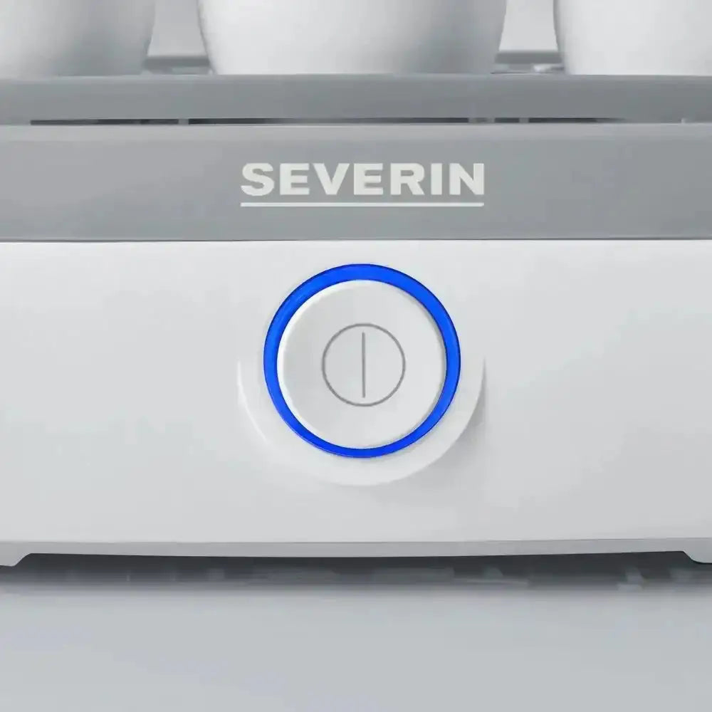 Close-up of electric egg boiler power button with visible eggs and illuminated blue ring