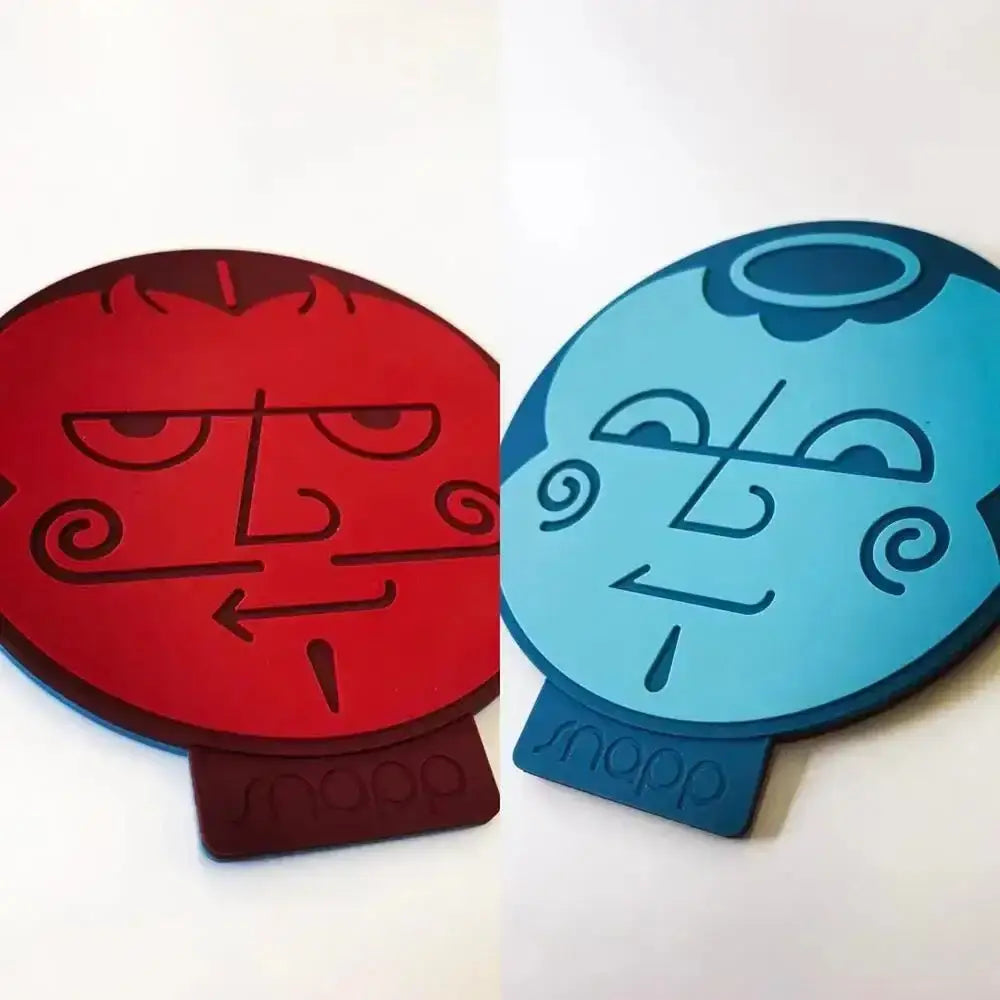 Two red and blue coasters with face designs on a white background