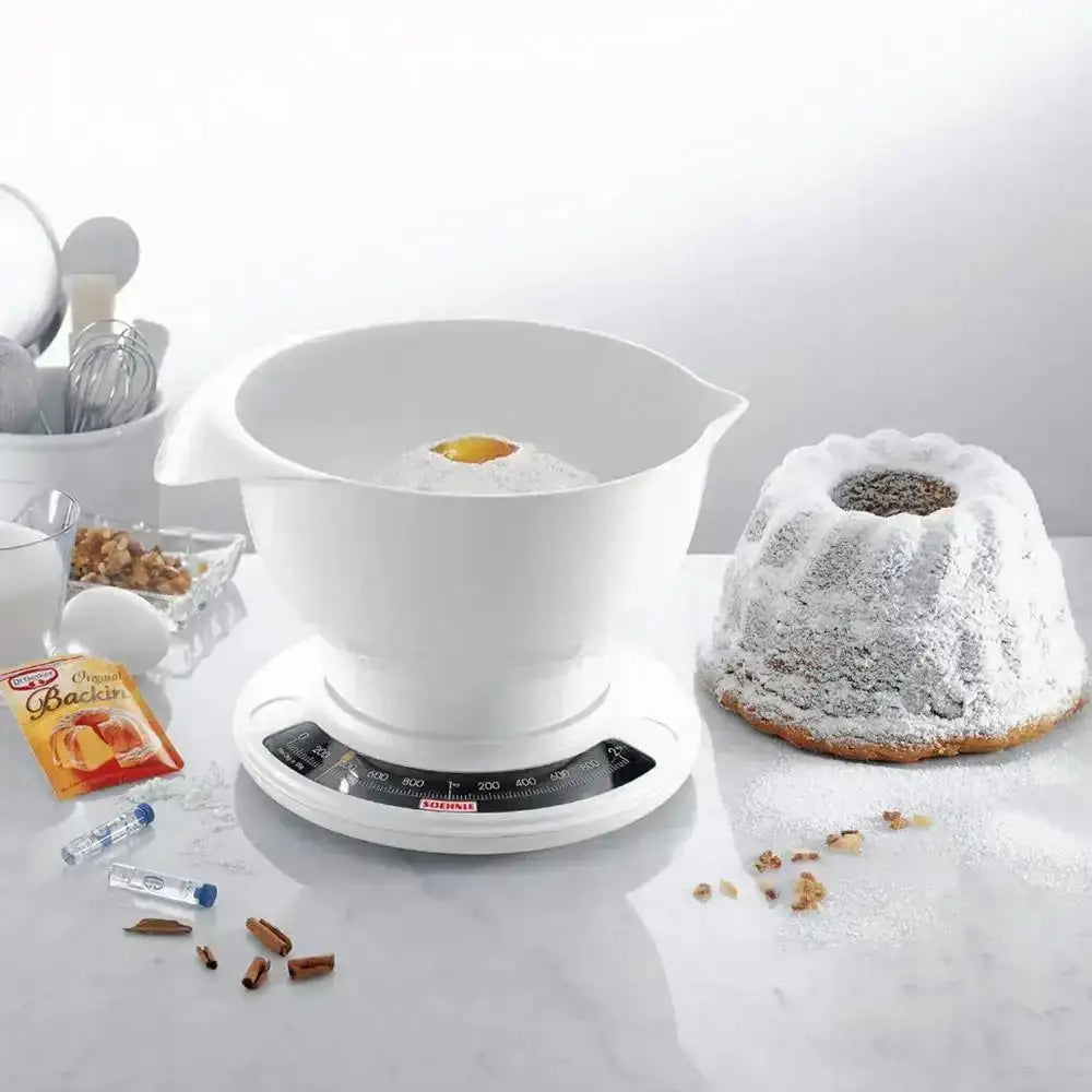 White kitchen scale with a bundt cake on a white surface