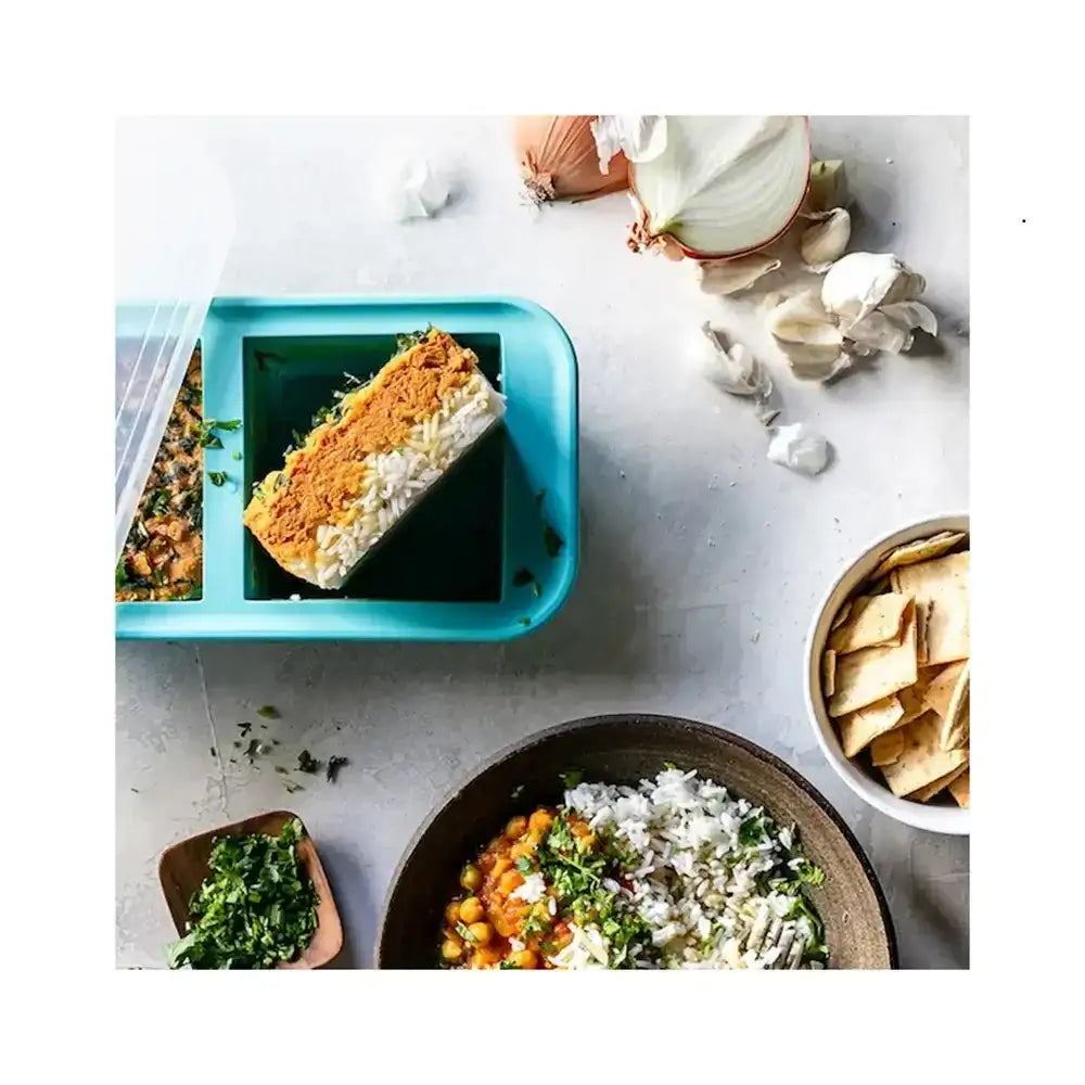 Prepared meals on a table with ingredients and containers.