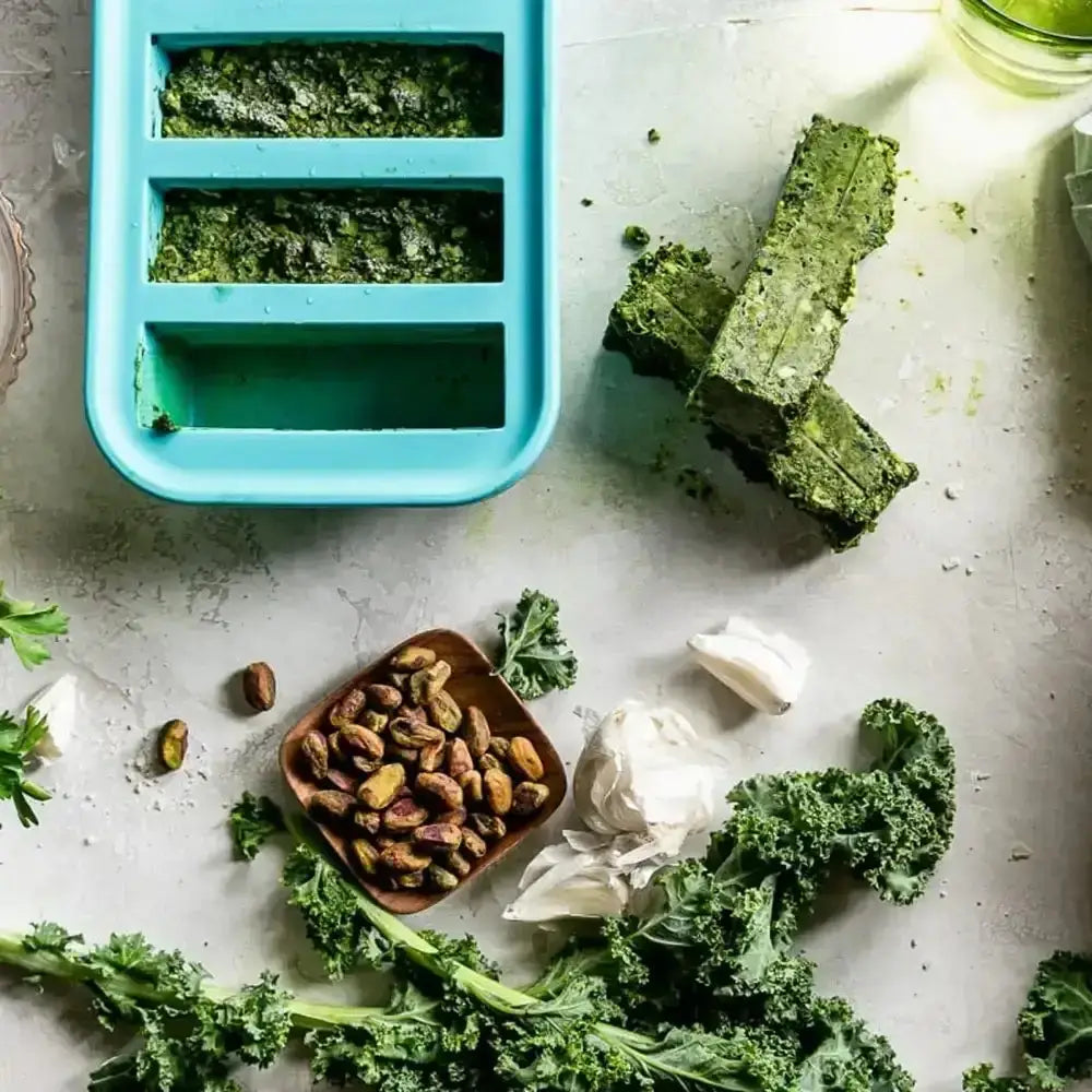 Green leafy vegetables in a silicone mold with ingredients on a light surface