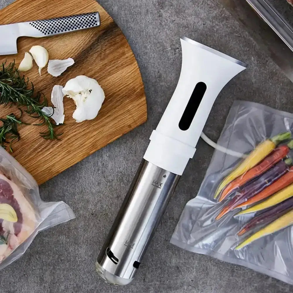 Vacuum sealer on a kitchen counter with vegetables and a cutting board.