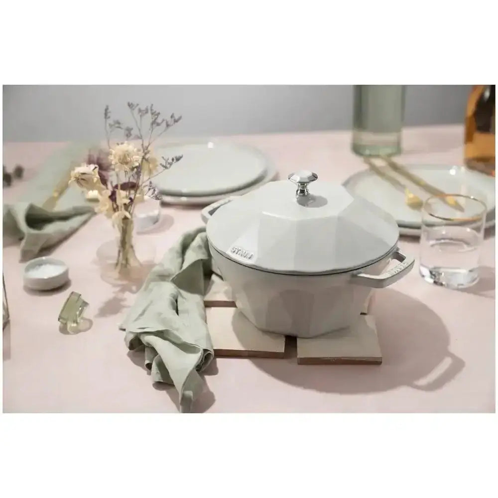 White ceramic pot on a pink tablecloth with decorative elements
