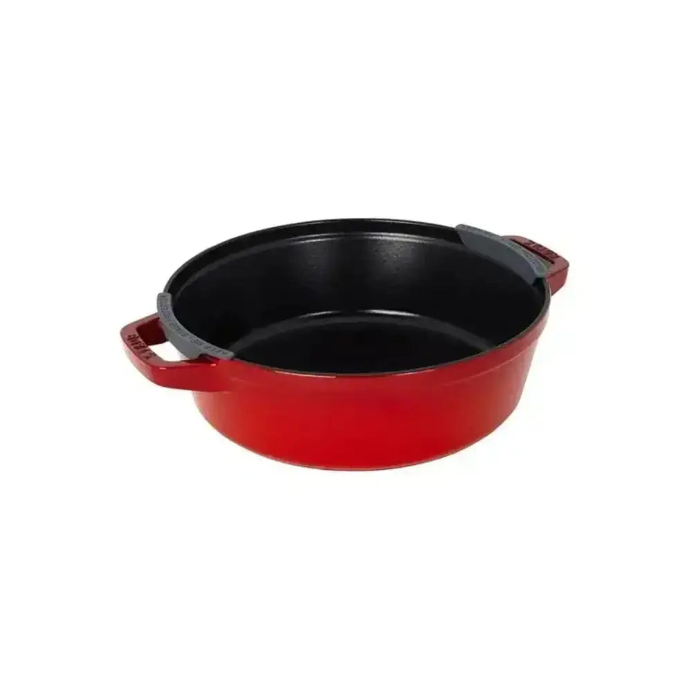 Red enameled cast iron dutch oven with black interior and gray silicone handles in Staub cast iron cookware set