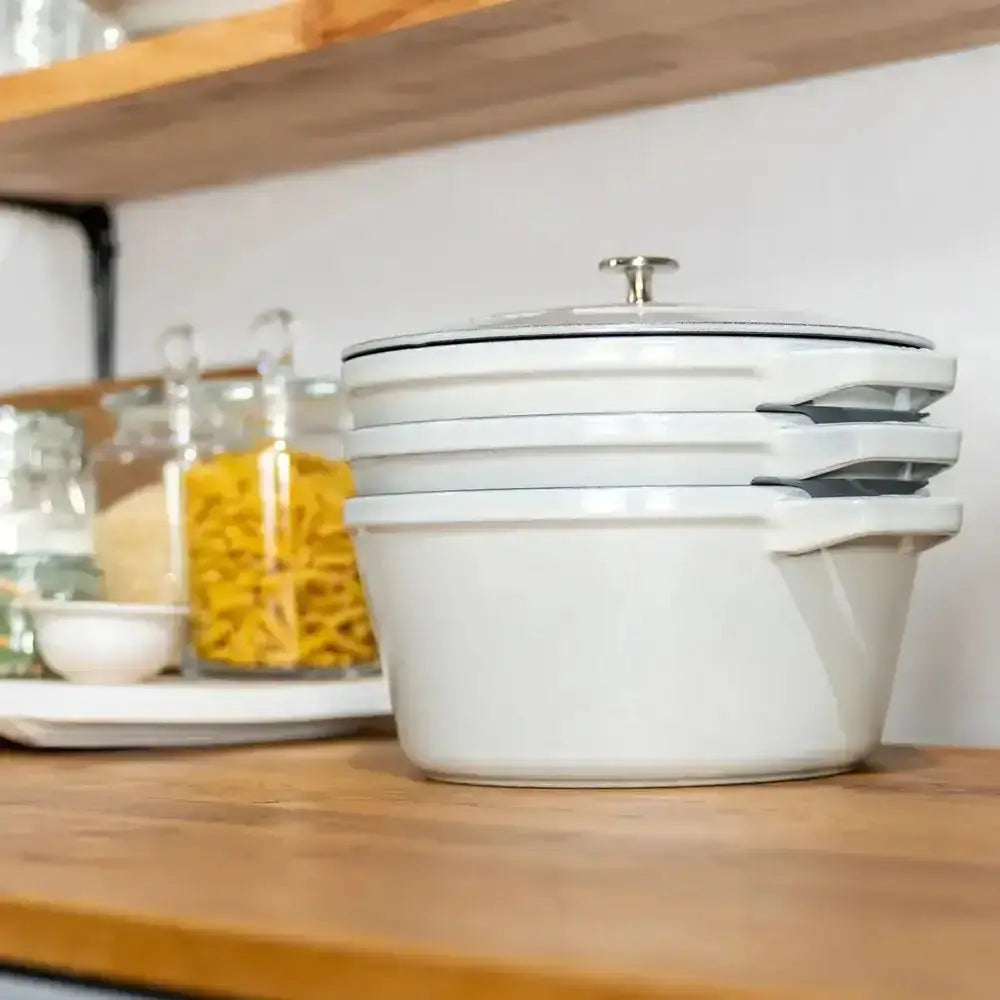 Staub cast iron stackable 4 piece cookware set in white truffle with enamel coating silver lids and handles