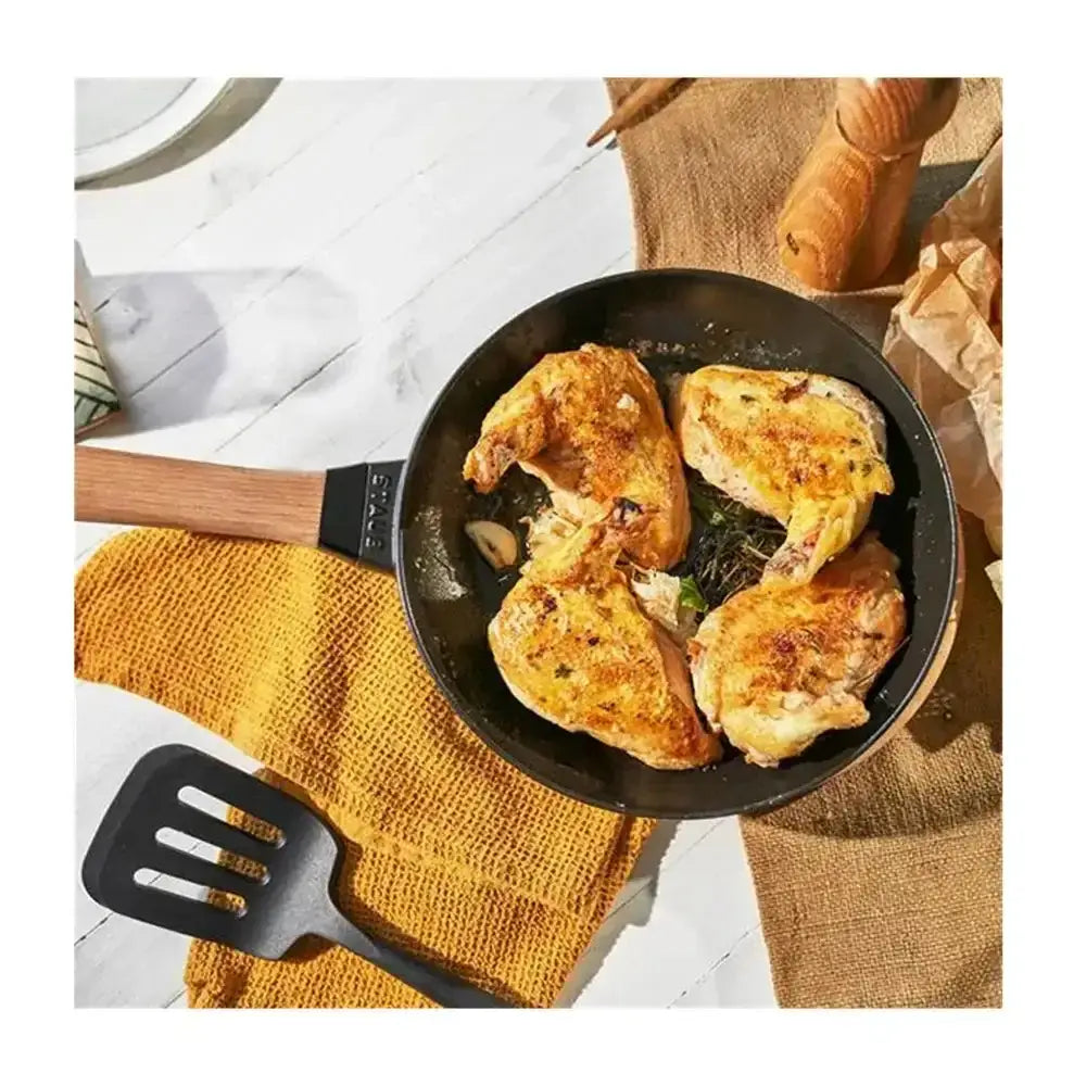 Black non stick Staub round cast iron frying pan 26cm with wooden handle and brand name engraved on the side