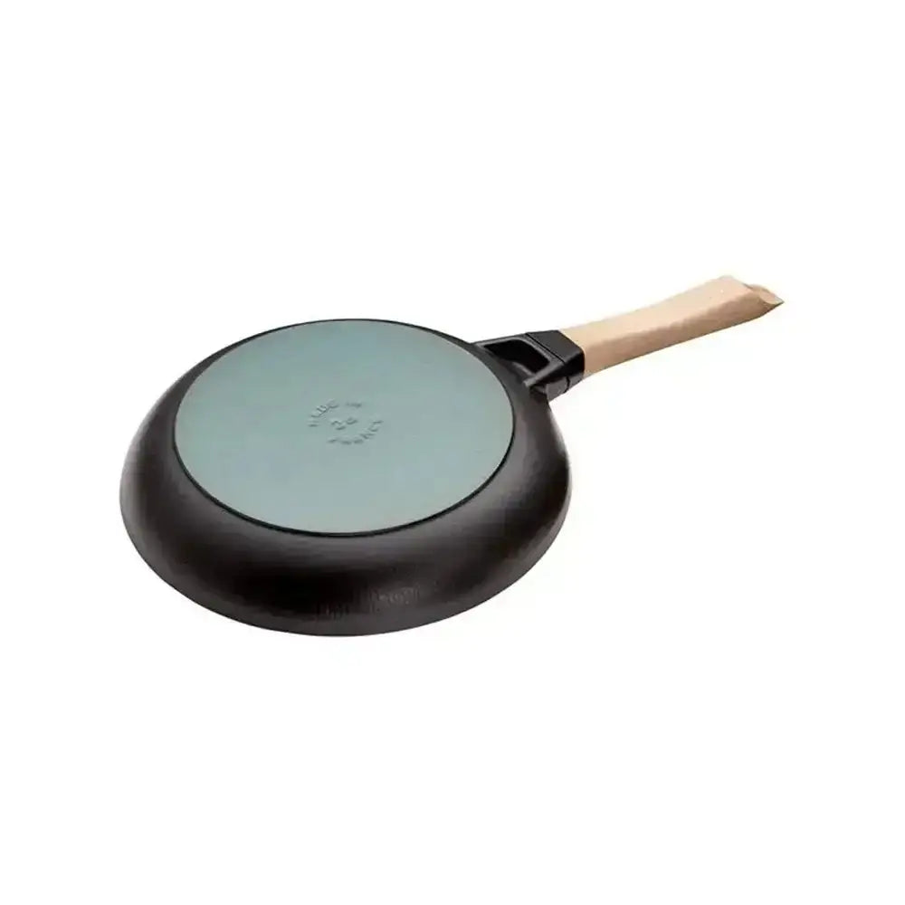 Staub round cast iron frying pan 28cm with black non-stick body, light blue cooking surface, and wooden handle