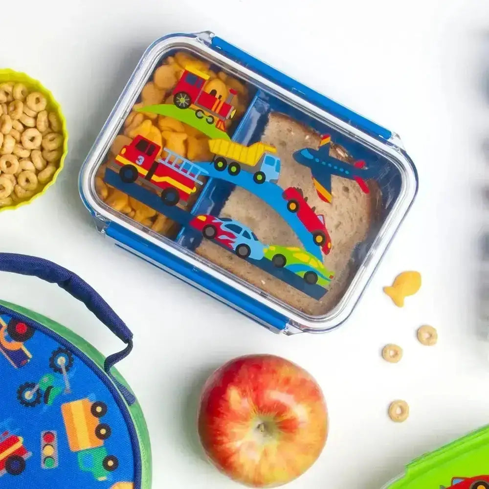 Children's lunchbox with toy cars and trucks, apple, and cheerios on a white background