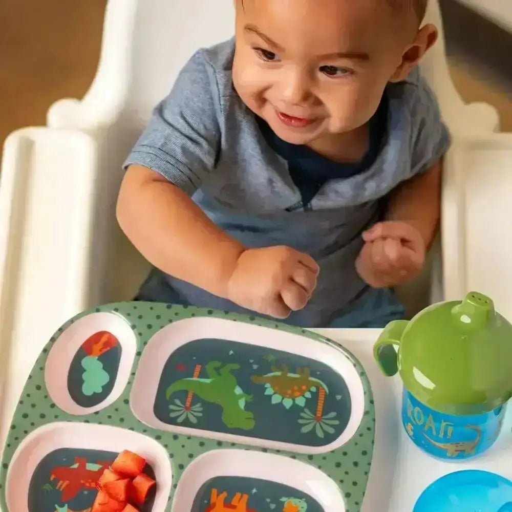 Child in a high chair with a colorful tray and green cup