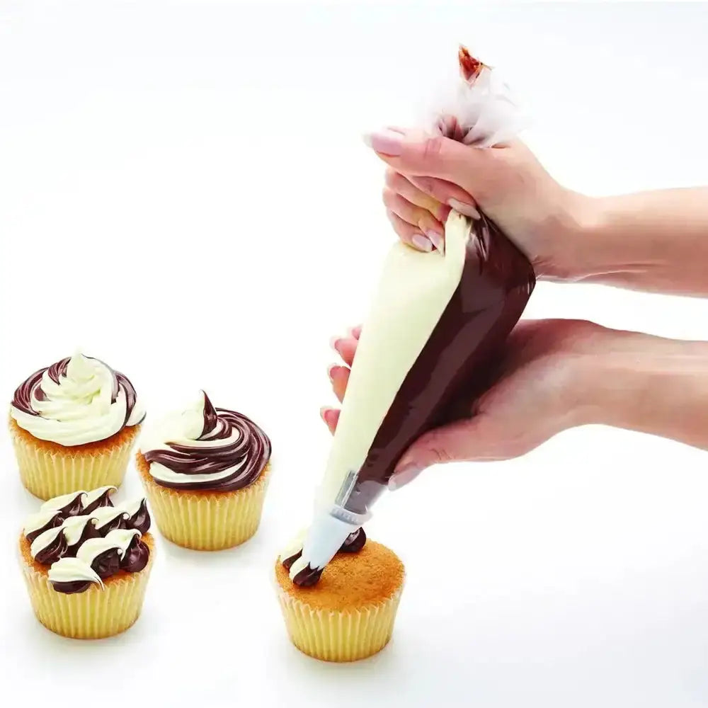 Hand using a piping bag to decorate cupcakes with chocolate and white frosting.
