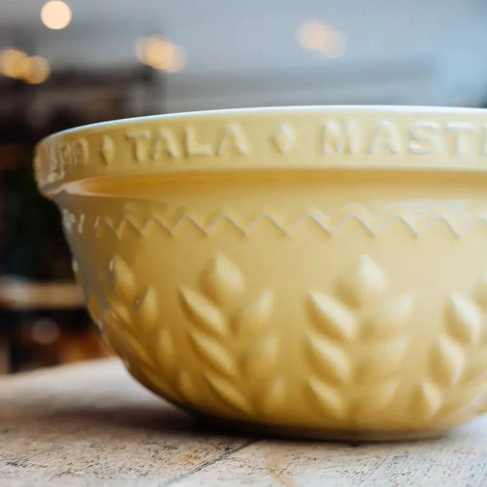 Yellow ceramic bowl with embossed design on a blurred background