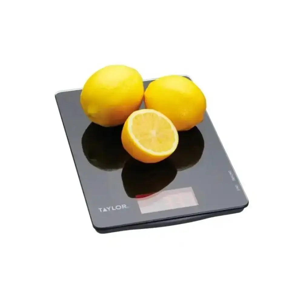 Three lemons on a Taylor digital kitchen scale against a white background