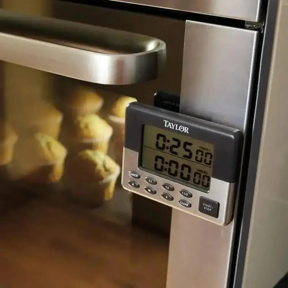 Digital timer attached to an oven displaying 25 minutes, with muffins inside the oven.
