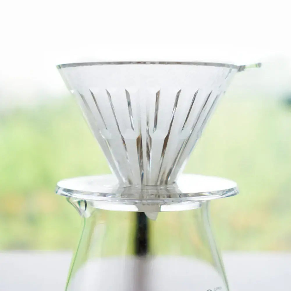 Clear coffee dripper on a blurred natural background