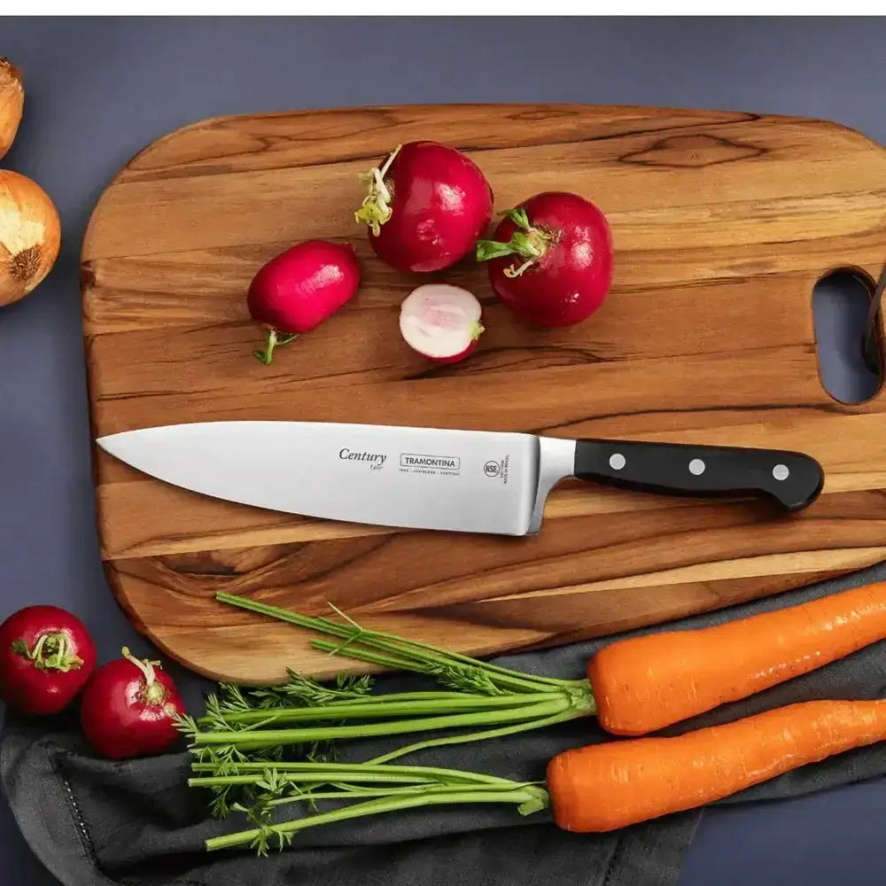 Wooden cutting board with radishes, carrots, and a knife on a dark surface