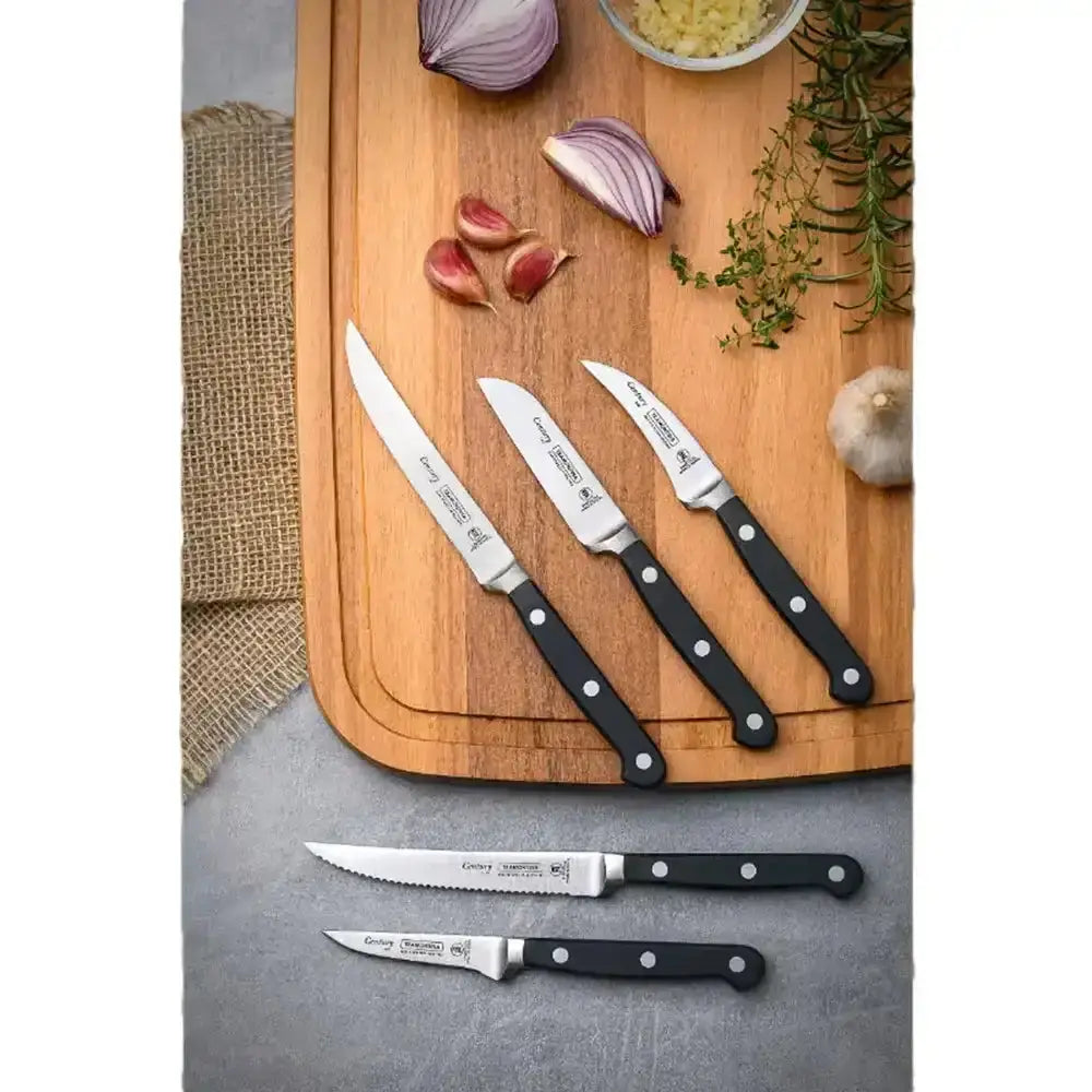 Set of knives on a wooden cutting board with vegetables