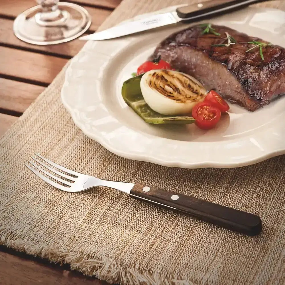 Steak with vegetables on a plate with a fork on a wooden table