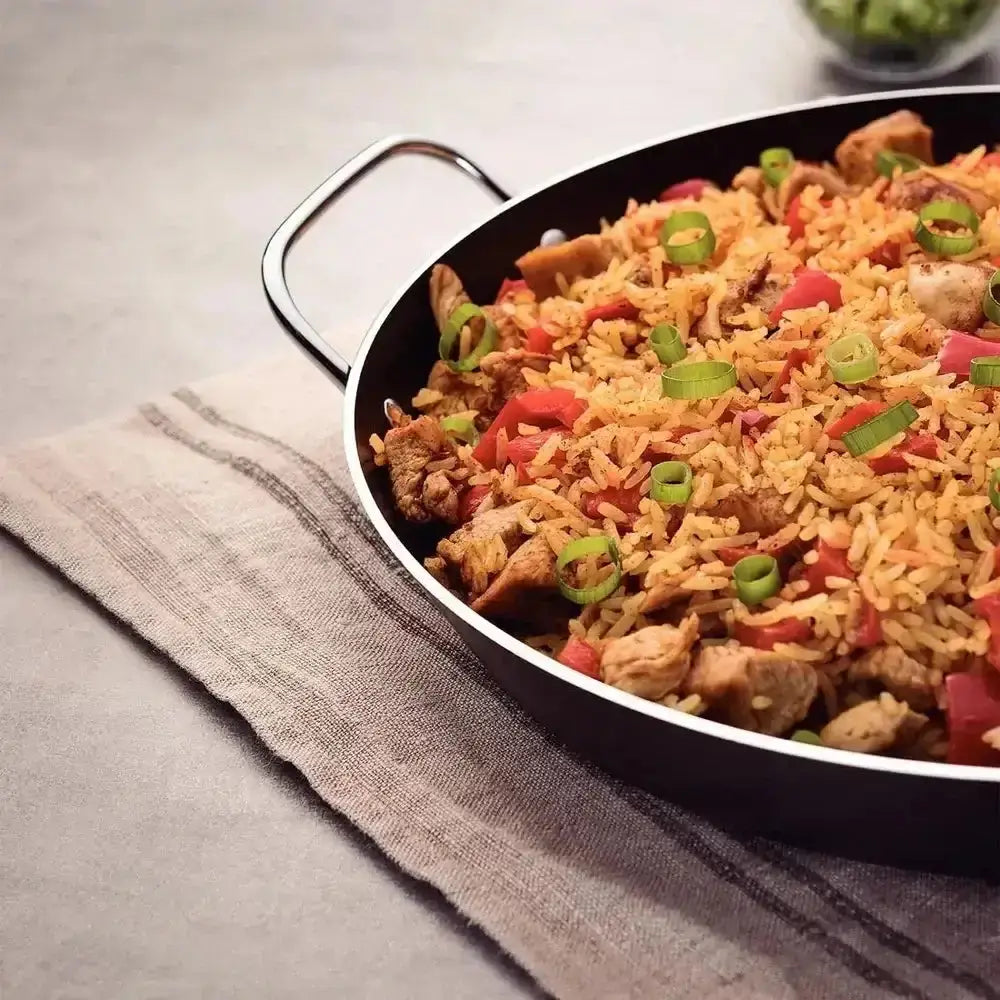 Paella dish in a pan on a textured surface