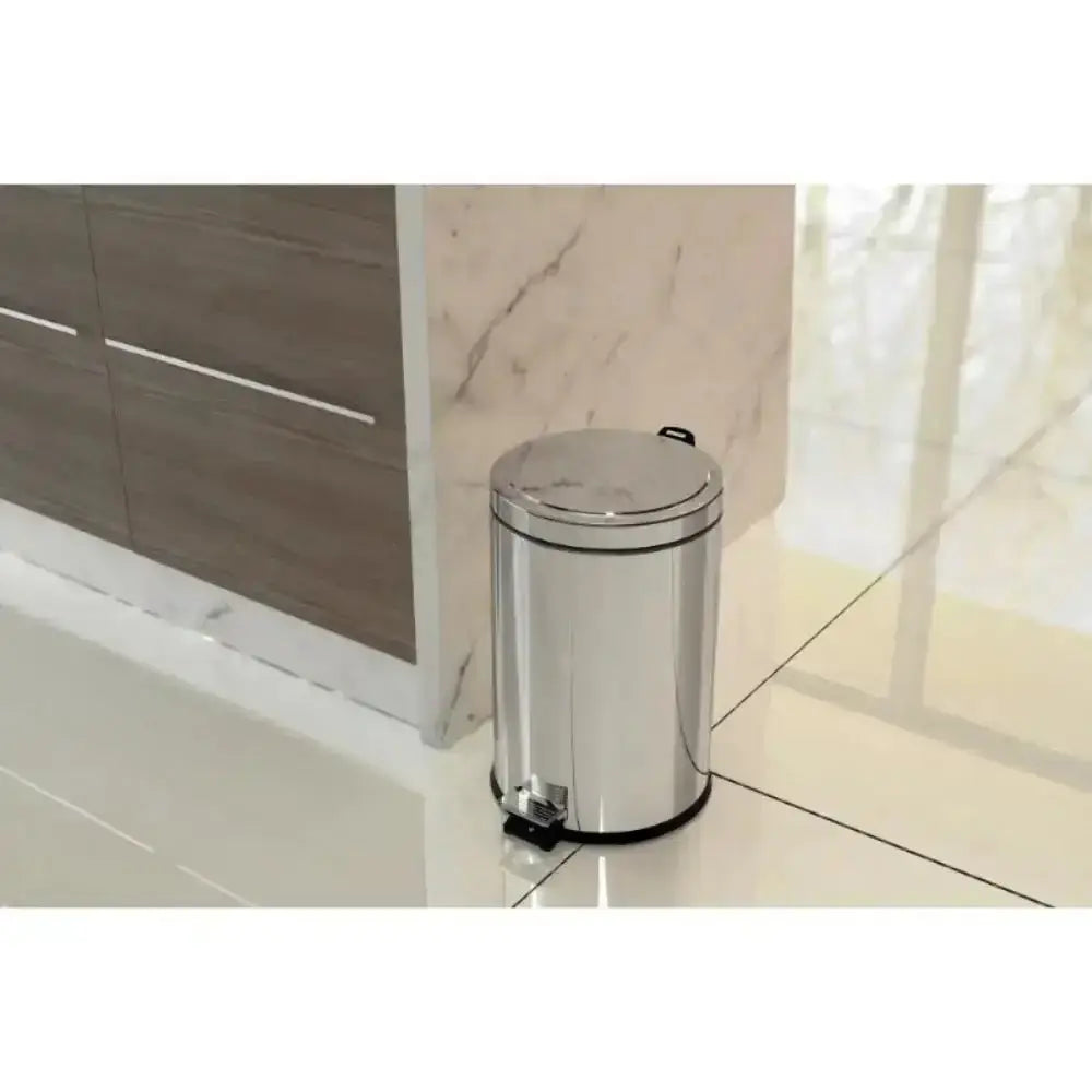 Silver trash can on a tiled floor next to a wooden cabinet