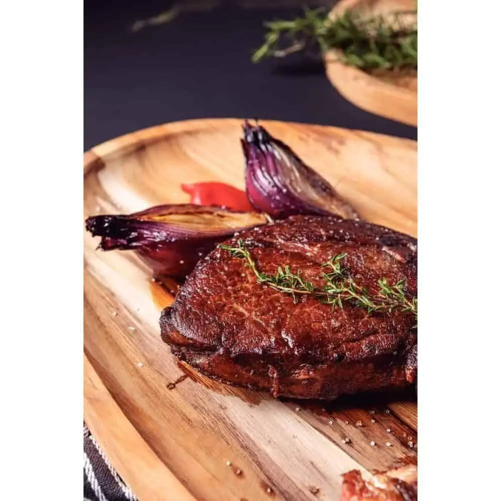 Grilled steak and roasted vegetables on a wooden serving board