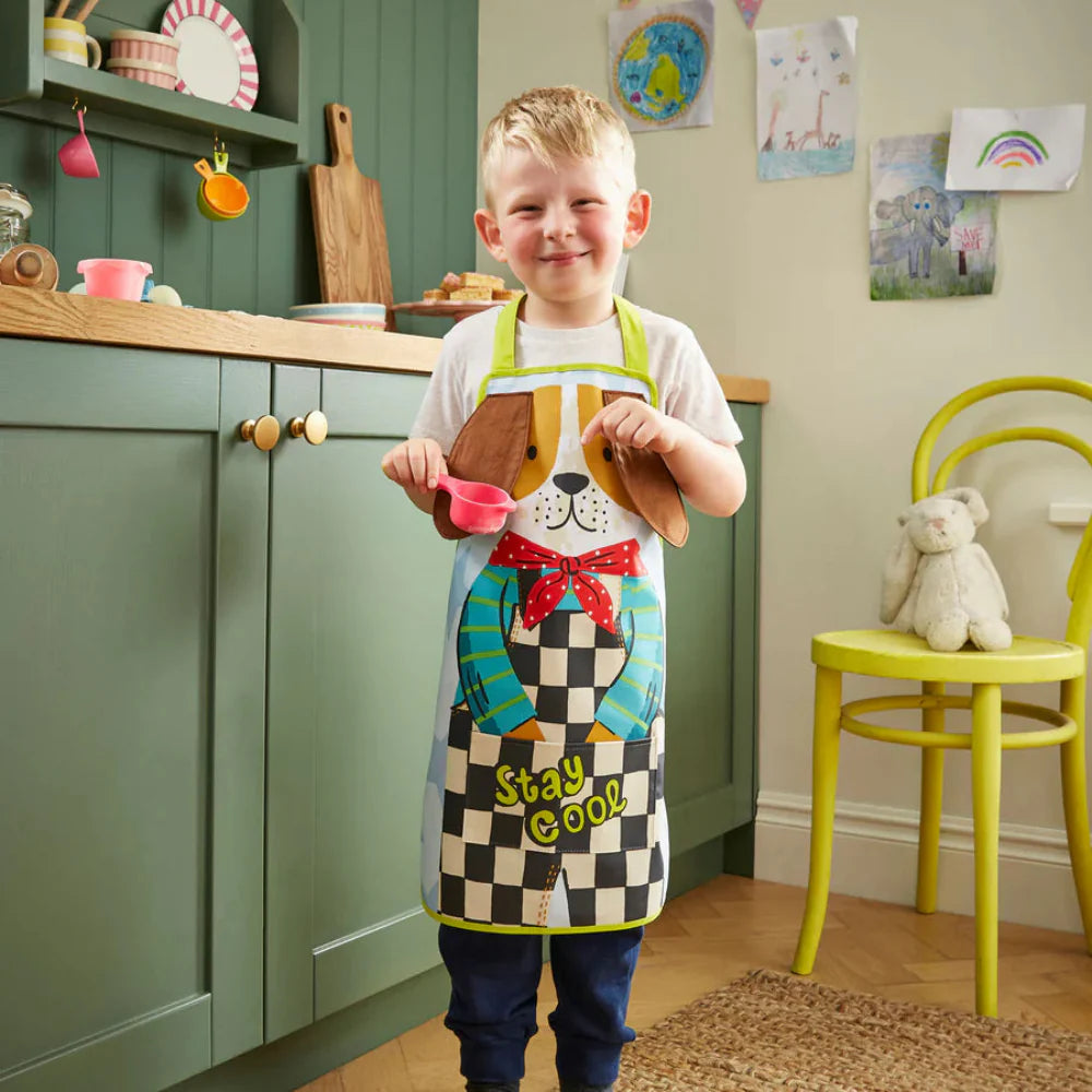 Child wearing a colorful apron in a kitchen setting