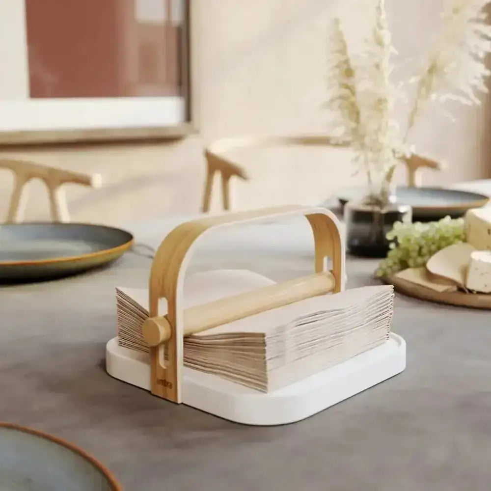 Napkin holder with napkins on a table in a home setting
