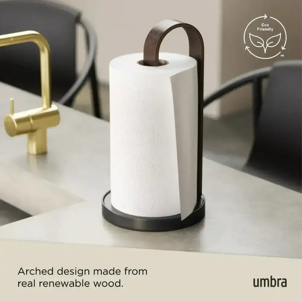 Umbra paper towel holder on a kitchen counter with 'Eco Friendly' label and text about renewable wood design.