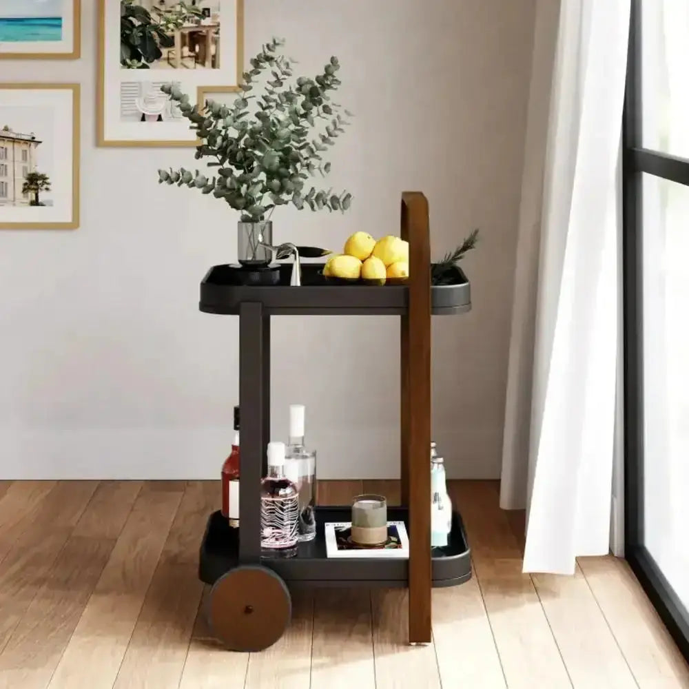 Bar cart with drinks and snacks in a room with framed pictures on the wall.