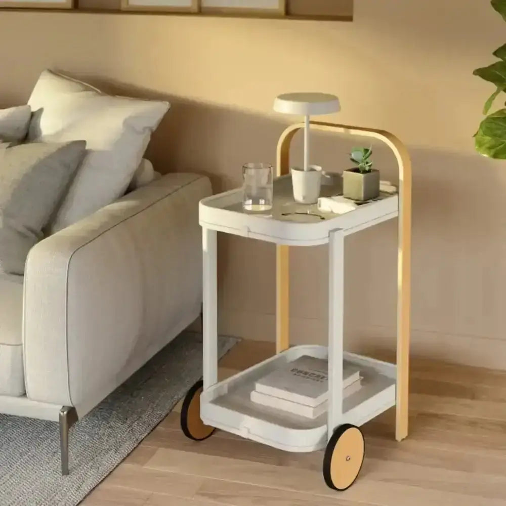White and gold side table with decorative items in a living room setting.