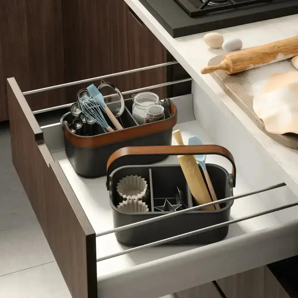 Kitchen drawer with organized storage bins containing utensils and kitchen tools.