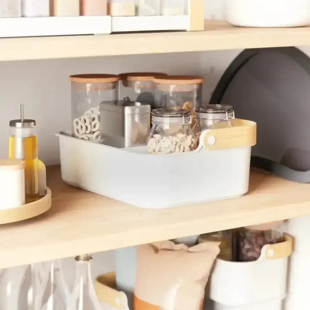 Kitchen storage containers on a wooden shelf with a neutral background
