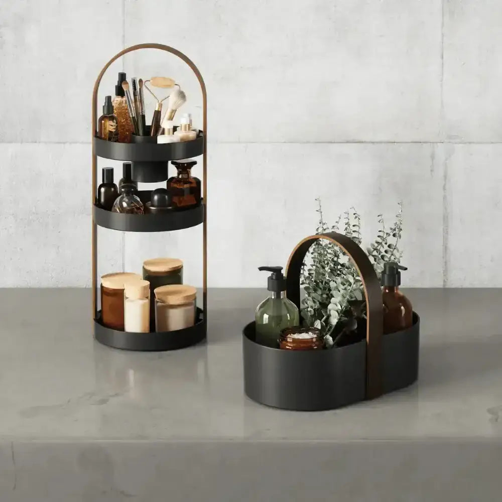 Two black metal organizers with various items on a gray surface and light gray tiled wall background.
