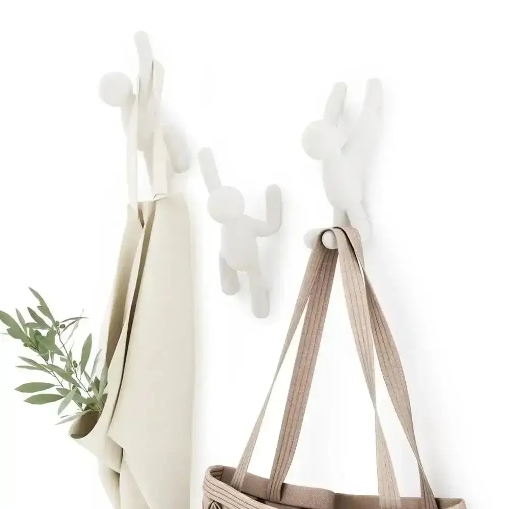 White wall hooks with a plant and bag on a white background