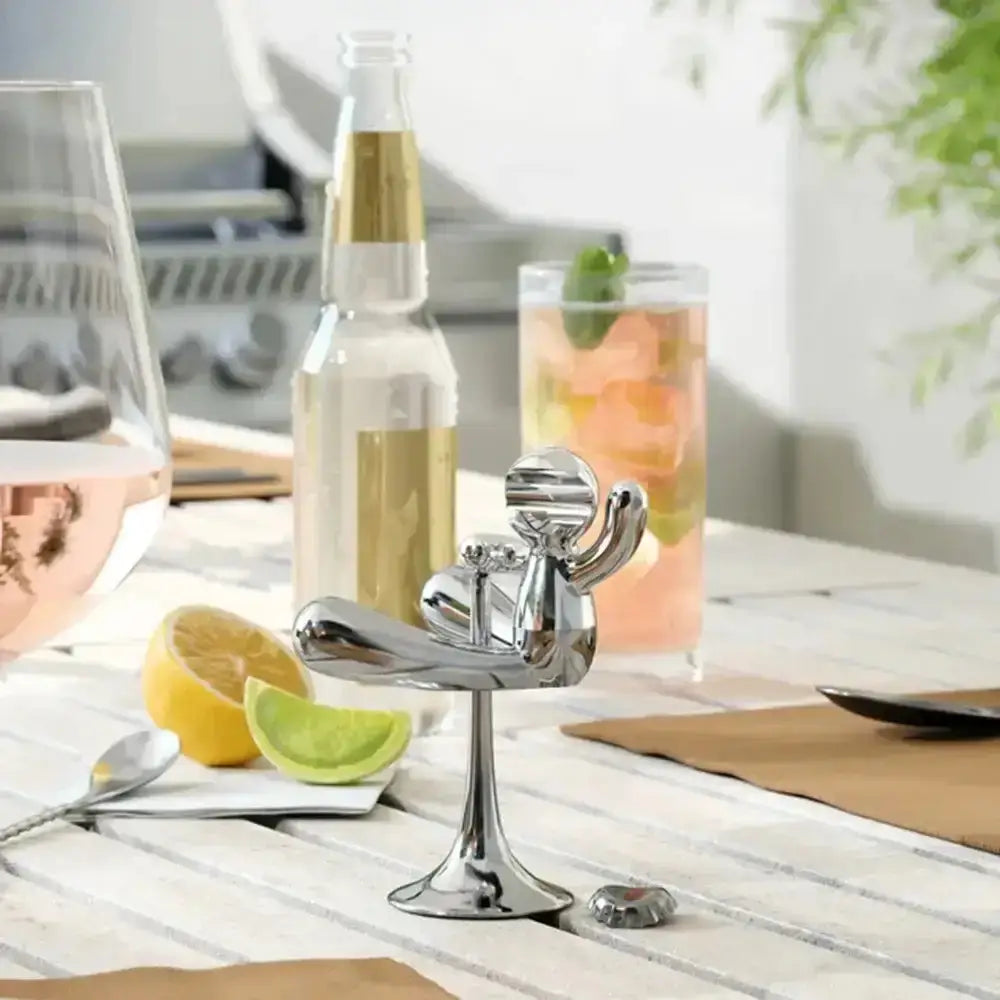 Chrome kitchen tool on a wooden countertop with glasses and lemons in the background