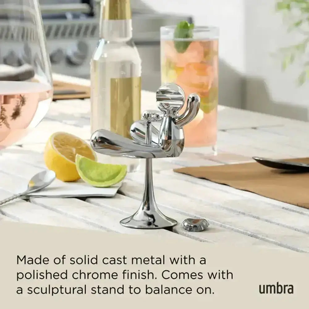 Chrome bottle opener on a stand with lemon and lime on a table, featuring the Umbra brand.