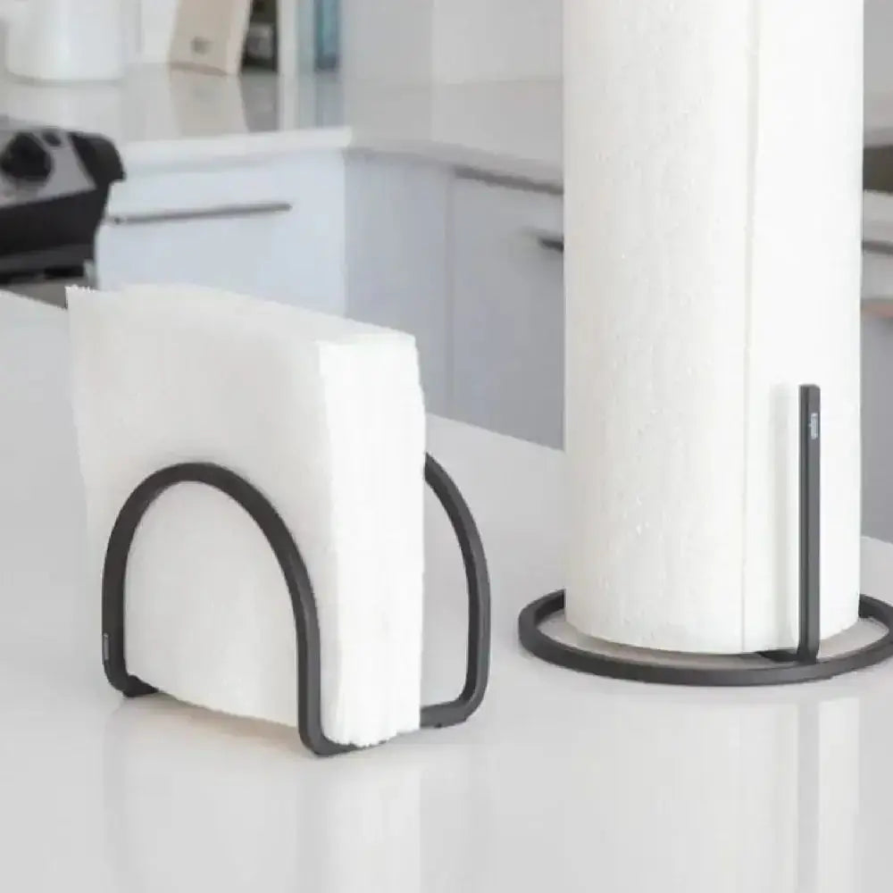 White paper towel holder on a white surface with a blurred background