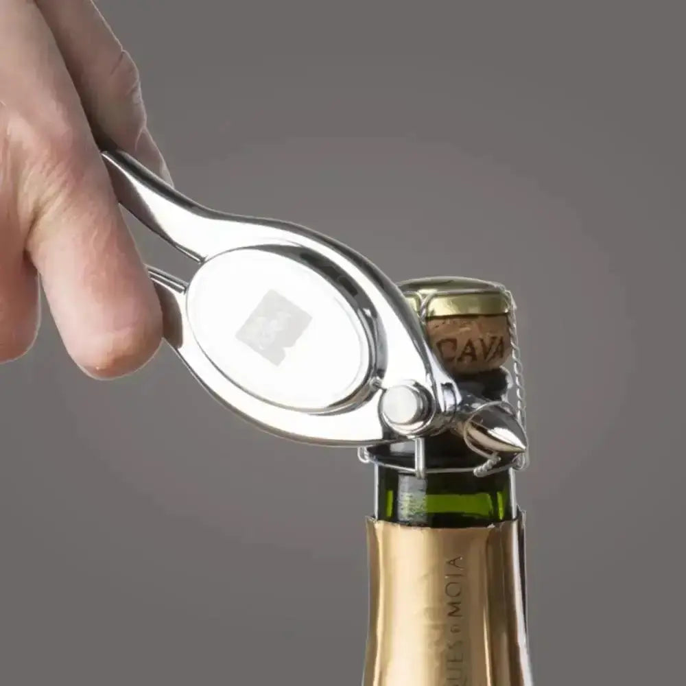 Hand using a corkscrew to open a bottle of champagne with a gray background